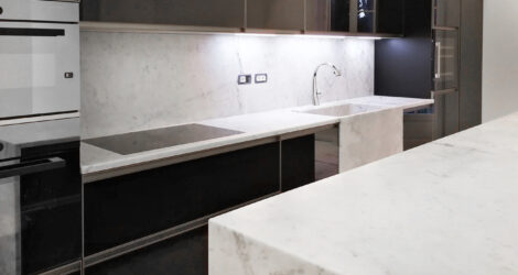 Appartamento con arredamento in marmo su misura: isola cucina, bagni, pavimento e camino