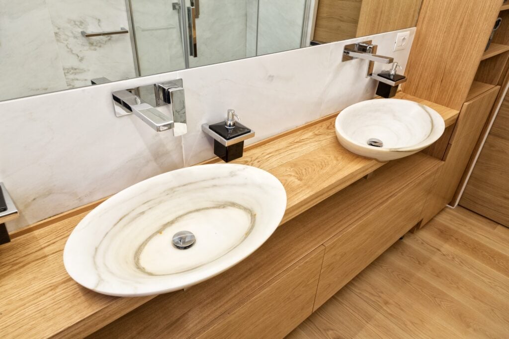 light marble sinks on wooden countertop